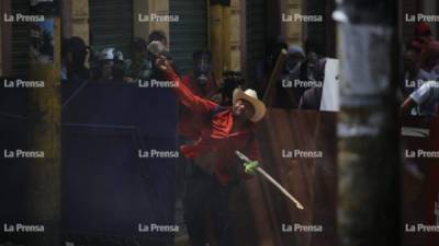 Un manifestante se enfrenta a un contingente de la Policía Nacional después de que lanzaran gases lacrimógenos en el centro de Tegucigalpa, capital de Honduras.