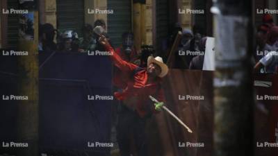 Un manifestante se enfrenta a un contingente de la Policía Nacional después de que lanzaran gases lacrimógenos en el centro de Tegucigalpa, capital de Honduras.