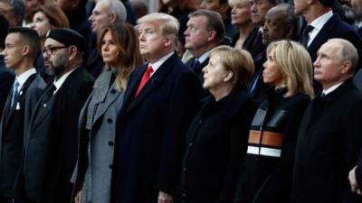 Morocco's King Mohammed VI (2nd L) and his son Crown Prince Hassan Moulay (L), US First Lady Melania Trump (3rd L), US President Donald Trump (C), German Chancellor Angela Merkel (3rd R), French President's wife Brigitte Macron (2nd R) and Russian President Vladimir Putin (R) attend a ceremony at the Arc de Triomphe in Paris on November 11, 2018 as part of commemorations marking the 100th anniversary of the 11 November 1918 armistice, ending World War I. (Photo by BENOIT TESSIER / POOL / AFP)