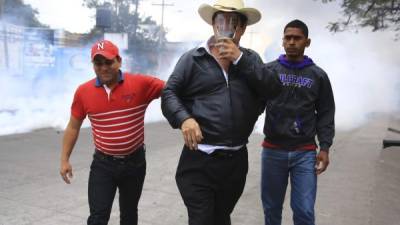 El expresidente de Honduras Manuel Zelaya, sale afectado por los gases lacrimógenos durante un enfrentamiento entre manifestantes y la policía hoy, sábado 20 de enero de 2018, en Tegucigalpa. EFE/Gustavo Amador