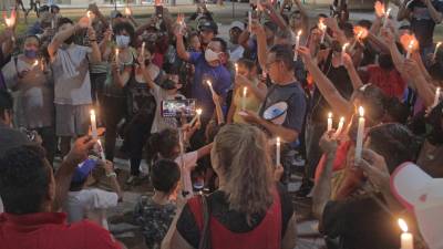 Migrantes indocumentados rezan durante una vigilia en la madrugada de hoy, en la ciudad de Tapachula (México).