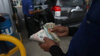 Un bombero de una estación de combustible se cerciorá de dar el cambio correcto a un cliente en San Pedro Sula.