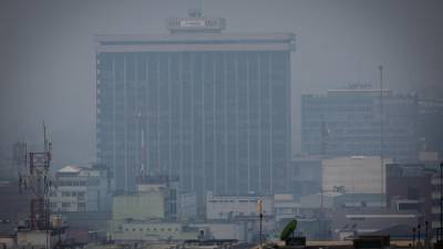 Fotografía que muestra una densa polución en el aire alrededor del edificio del ministerio de Finanzas este lunes en el centro histórico de la Ciudad de Guatemala (Guatemala).