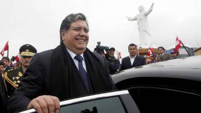 Un hombre se arrodilla junto al ataúd de Jack Bryan Pintado Sánchez, un joven de 22 años que murió durante las protestas del fin de semana contra la destitución del presidente Martín Vizcarra por parte de los legisladores, en una iglesia durante su velatorio en Lima, Perú, el lunes 16 de noviembre de 2020. (AP Foto/Rodrigo Abd)