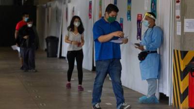 Un médico con traje de bioseguridad trabaja en el triaje en el Centro Cristiano Internacional CCI) de atención temprana.