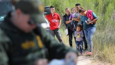 MCALLEN, TX - JUNE 12: Central American asylum seekers wait as U.S. Border Patrol agents take groups of them into custody on June 12, 2018 near McAllen, Texas. The families were then sent to a U.S. Customs and Border Protection (CBP) processing center for possible separation. U.S. border authorities are executing the Trump administration's zero tolerance policy towards undocumented immigrants. U.S. Attorney General Jeff Sessions also said that domestic and gang violence in immigrants' country of origin would no longer qualify them for political-asylum status. (Photo by John Moore/Getty Images)