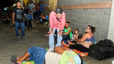 Migrantes esperando abordar los buses en la terminal.