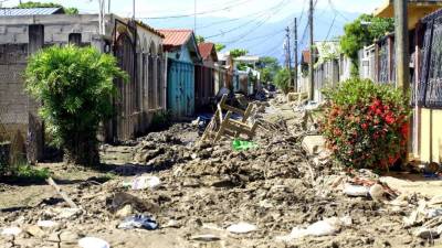 A diario familias llegan a limpiar sus casas a la colonia Céleo Gonzales con la esperanza de habitarlas, pero la acumulación de lodo y basura no se los permite porque las calles están intransitables. Fotos: Moisés Valenzuela.