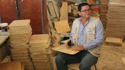 Marlon Escoto revisando los pupitres en el taller.