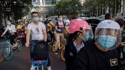Los ciudadanos chinos usan sus mascarillas en interiores y exteriores sin excepciones./AFP.