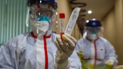 This photo taken on February 4, 2020 shows a medical staff member showing a test tube after taking samples taken from a person to be tested for the new coronavirus at a quarantine zone in Wuhan, the epicentre of the outbreak, in China's central Hubei province. - The world has a 'window of opportunity' to halt the spread of a deadly new virus, global health experts said, as the number of people infected in China jumped to 24,000 and millions more were ordered to stay indoors. (Photo by STR / AFP) / China OUT