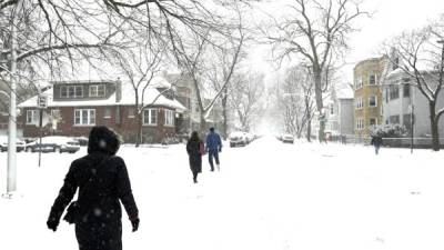 JSX06. Chicago (United States), 24/12/2017.- People are seen walking on the snow covered streets of the Lakeview neighborhood of Chicago, Illinois, USA, 24 December 2017. (Estados Unidos) EFE/EPA/JASON SZENES
