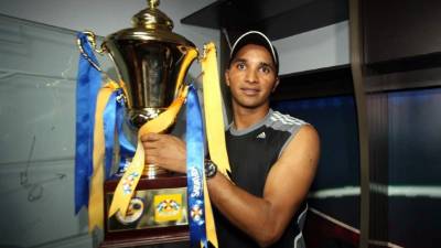 Donis Escober posa con la copa de campeones.