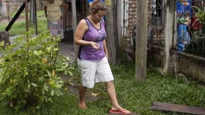 Teresa Muñoz, madre de la Miss Mundo Honduras María José y Sofía Trinidad Muñoz, que aparecieron muertas el 19 de noviembre, sale de su casa este miércoles 26 de noviembre de 2014, en el barrio Galeras de Santa Bárbara (Honduras). Teresa Muñoz exigió hoy que la 'justicia' alcance a Plutarco Ruiz, quien para ella es 'el principal culpable' del asesinato la semana pasada de sus hijas. EFE