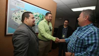 El abogado de Ham, Pedro Velásquez (camisa verde), y Manrique Juárez (saco gris) saludan al director del INA, Ramón Lara.