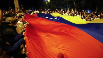 Ciudadanos venezolanos se reúnen a la espera de los resultados de las elecciones presidenciales en su país, este domingo en Quito (Ecuador). EFE/ José Jácome.