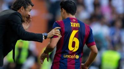 Xavi Hernández dialoga con Luis Enrique durante el clásico.