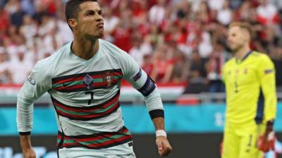 Portugal's forward Cristiano Ronaldo celebrates after scoring his team's second goal during the UEFA EURO 2020 Group F football match between Hungary and Portugal at the Puskas Arena in Budapest on June 15, 2021. (Photo by BERNADETT SZABO / POOL / AFP)