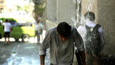 URU4. MONTEVIDEO (URUGUAY) 29/12/2017.- Transeúntes son mojados por habitantes de edificios hoy, 29 de diciembre de 2017, en Montevideo (Uruguay). Los montevideanos celebran cada final de año nuevo con la tradición de romper calendarios y tirar agua por las ventanas a los transeúntes que pasan por las calles del barrio Ciudad Vieja en donde se concentra parte de la actividad económica del lugar. EFE/Raúl Martínez