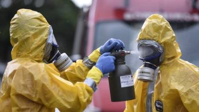 Dos personas utilizan traje para prevenir el Covid-19 en Brasil. Foto: AFP