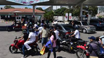 Personas se abastecen de combustible este miércoles 18 de marzo en Tegucigalpa. Foto: AFP