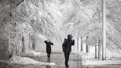 Peatones caminan por una acera nevada junto a la avenida Pennsylvania durante una tormenta de nieve en Washington, DC, Estados Unidos.