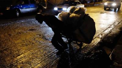 Un cartonero que con cargas de hasta de 150 kilos, llega a recorrer distancias hasta de 10 kilómetros en San José (Costa Rica). Mucho del material recolectado por los 'cartoneros' es ordenado y separado para su reciclaje. Invisibles ante los ojos de los transeúntes citadinos, los 'cartoneros', en su mayoría indigentes, al ritmo de las hormigas de trabajo recolectan los cartones desperdigados de los comercios de la capital en San José, Costa Rica. La suma del material recopilado por los cartoneros puede ascender a 8 toneladas diarias, según comenta Víctor Calvo, propietario del centro de reciclaje donde se realiza el acopio de los desechos en San José. Con una paga por kilo de 35 colones ($0,06), se convierte en un pequeño ingreso para estas personas que en su mayoría son dependientes de las drogas y que por esta labor muchos han dejado de robar. EFE/Jeffrey Arguedas.