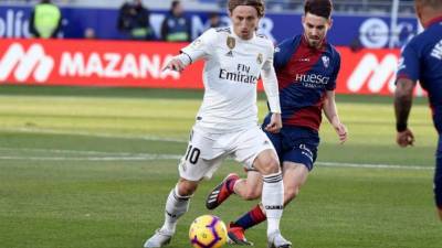 El delantero croata del Real Madrid Luka Modric (i) y el cenrocampista del Huesca Moisés Gómez durante el partido de la decimoquinta jornada de Liga que disputaron en el estadio oscense de El Alcoraz. EFE