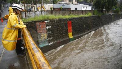 Un miembro de protección civil inspecciona el caudal de un río en San Salvador (El Salvador).