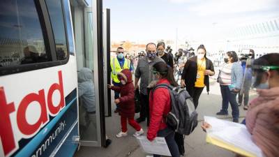 Unos solicitantes de asilo bajo el Protocolo de Protección a Migrantes, mejor cono conocido como MPP, se suben a un autobús luego de ingresar a los Estados Unidos por el Cruce Internacional Santa Fe en El Paso, Texas.