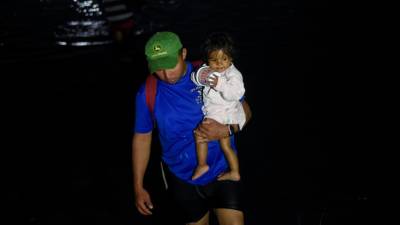 Migrantes cruzan el río Suichate de regreso a Tecun Uman, luego de no poder ingresar a Ciudad Hidalgo, México.