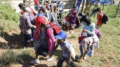 Un grupo de migrantes hondureños tratan de evitar los puntos de control migratorio recorriendo otros caminos en el Municipio de Omoa (Honduras).