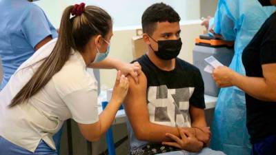 Labor. Una enfermera vacuna contra el covid-19 a un joven en Diunsa. Foto: Cortesía Carlos Hernández.