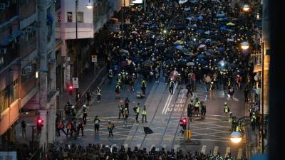 Los manifestantes se enfrentan a la policía (abajo) durante una manifestación contra un controvertido proyecto de ley de extradición en Hong Kong .