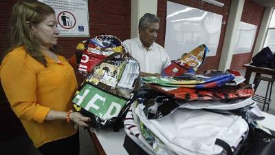 La catedrática Suyapa Villatoro cuando entregaba mochilas y cuadernos al director Víctor Cortés. Foto: Wendell Escoto.