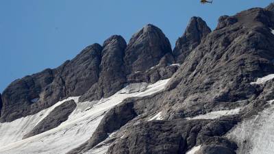 Un helicóptero sobrevuela hoy la montaña Marmolada, en los Dolomitas (Alpes italianos) tras la avalancha de este domingo.
