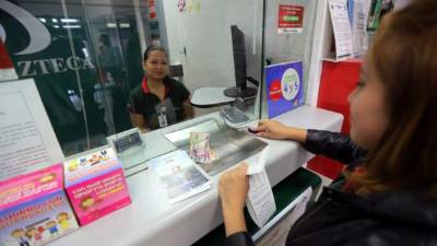 Una mujer atendida en una caja de Banco Azteca.