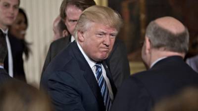 US President Donald Trump, surrounded by members of his cabinet, speaks before signing an executive order entitled Comprehensive Plan for Reorganizing the Executive Branch in the Oval Office at the White House in Washington, DC, on March 13, 2017. / AFP PHOTO / NICHOLAS KAMM