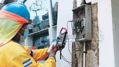 <b><span class=mln_uppercase_mln>Un empleado de la Empresa Energía Honduras revisa una conexión eléctrica.</span></b>
