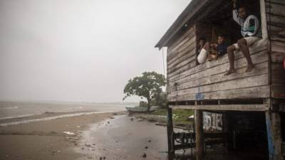 Children sit on a beach house window as Hurricane Eta approaches in Bilwi, Puerto Cabezas, Nicaragua, on November 2, 2020. - Eta rapidly intensified to a Category 4 hurricane on Monday as it bore down on the Caribbean coast of Nicaragua and Honduras, threatening the Central American countries with catastrophic winds and floods. (Photo by INTI OCON / AFP)