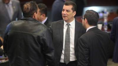 El diputado Elvin Santos platica con los parlamentarios Carlos Zelaya y Jorge Cálix de Libre en el Congreso Nacional.