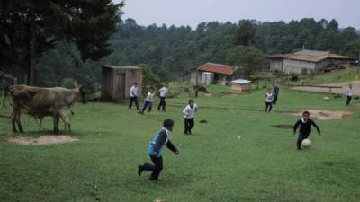 Alumnos del Centro de Educación Básica Integración Centroamericana (CEBIC) juegan al fútbol en la aldea el Zancudo, departamento de La Paz, situada en uno de los seis bolsones (territorios) de la frontera común entre Honduras y El Salvador.