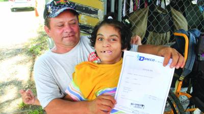 <b>Necesidad.- </b>Denis González junto con su pequeña muestra el examen médico que debe hacerle.