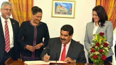 El presidente firmó acuerdos con la primera ministra trinitense Kamla Persad Bissessar, a su izquierda.