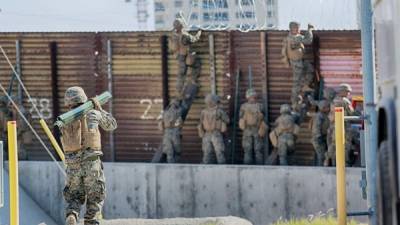 Un grupo de infantes de marina estadounidenses colocando alambre de púa sobre la cerca de la frontera México-Estados Unidos en San Ysidro, California. (Photo by Sandy Huffaker / AFP)