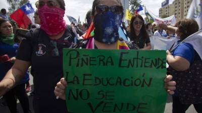 Las calles de Santiago se llenaron ayer de gremios de maestros, estudiantes y trabajadores de la salud para exigir que estos dos rubros aparezcan en la Constitución como un derecho responsabilidad del Estado. Foto:AFP