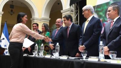 Representantes de la fundación y el presidente Juan Orlando Hernández reconocen a los becarios.