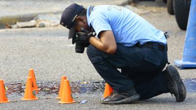 Un agente de investigación de la Policía Nacional en una escena del crimen.