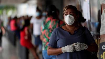 Una mujer con tapabocas fue registrada este miércoles al hacer fila para mercar, en Ciudad de Panamá (Panamá). EFE/Bienvenido Velasco