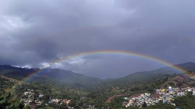 Fotografía de un sector de Tegucigalpa donde cae una llovizna y se forma un arcoíris, el 14 de noviembre de 2023, en Tegucigalpa (Honduras).